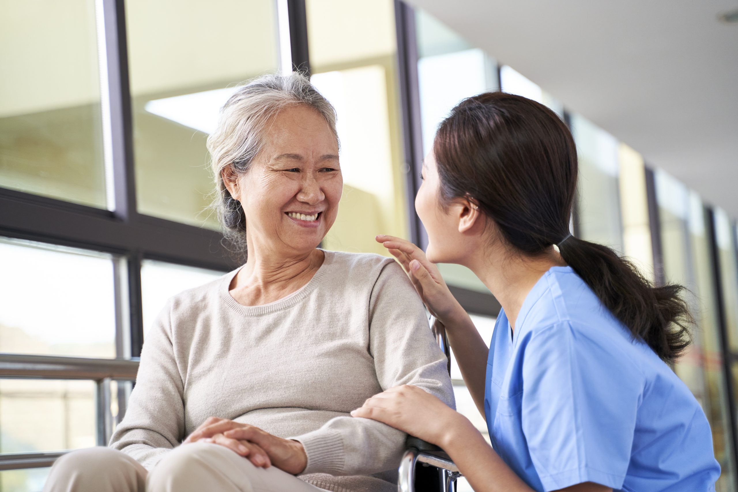 friendly nurse talking with happy senior woman